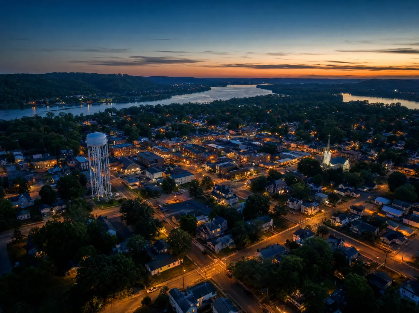 A small Missouri town at dusk with window lights coming on